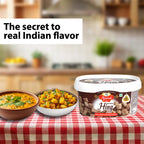 Container of 106 No, Compounded Hing Cubes with Indian dishes on a table in a kitchen setting