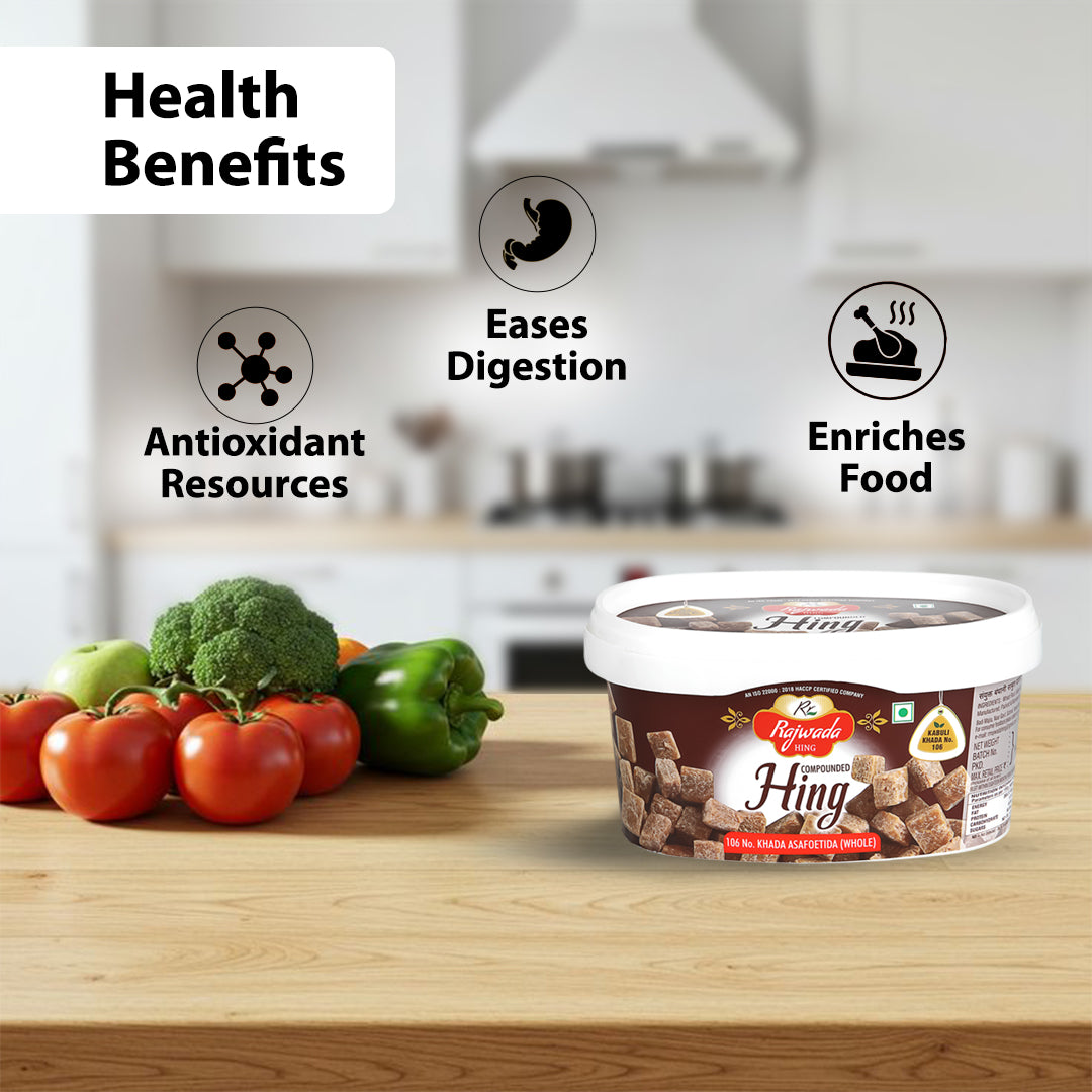 Container of 106 No, Compounded Hing Cubes with health benefits listed and vegetables on a kitchen counter
