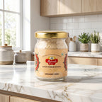 Jar of Rajwada- Gold Hing on a kitchen counter with a window in the background