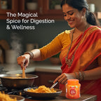 Woman cooking in a kitchen with a container of Sanyukt Bandhani Hing Platinum Powder labeled 'The Magical Spice for Digestion & Wellness'.