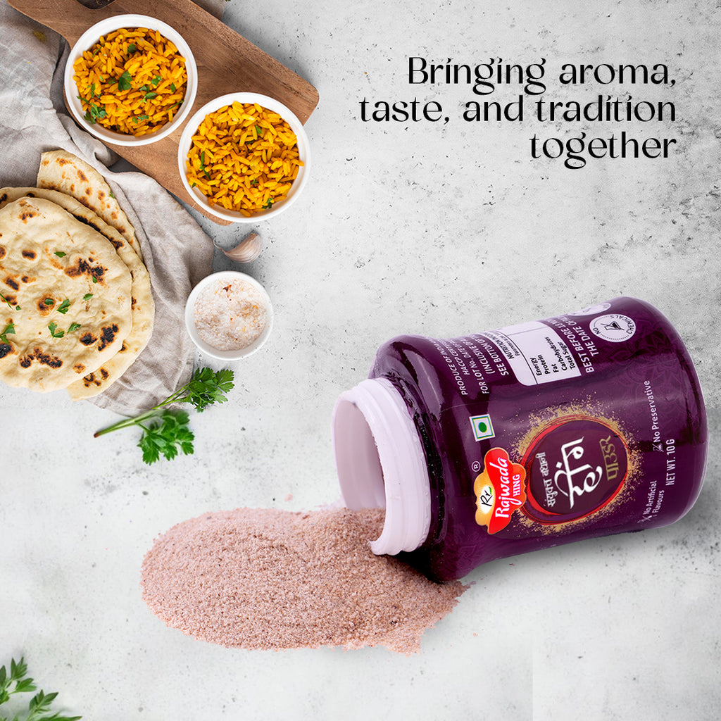 Sanyukt Bandhani Hing Powder – Premium Quality for Perfect Tadka container with a spread of spices on a table with food items